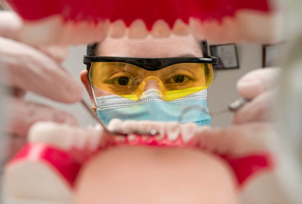 Dentist examining a patient's mouth during a first dental checkup in Highland, IN